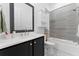Bathroom features vanity with black cabinets, white countertop, framed mirror and tiled tub and shower at 1103 Briar Cove Ne Cir, Atlanta, GA 30329