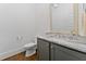 Bathroom with marble countertops, gray cabinetry, and a framed mirror at 1103 Briar Cove Ne Cir, Atlanta, GA 30329