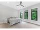 Bedroom with three large windows, ceiling fan, and a bed with a patterned cover at 1103 Briar Cove Ne Cir, Atlanta, GA 30329