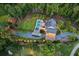 Beautiful aerial shot of a home surrounded by trees with a pool and extensive driveway with manicured grounds at 150 Trinity Farm Dr, Canton, GA 30115