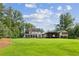 Lush, green backyard featuring a well-manicured lawn, and a covered patio area at 150 Trinity Farm Dr, Canton, GA 30115