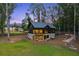 Modern home features a stone facade, a lush backyard, and an outdoor living space at 150 Trinity Farm Dr, Canton, GA 30115