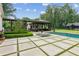 Beautiful backyard showcasing a pool, outdoor kitchen under a covered patio, and lush landscaping at 150 Trinity Farm Dr, Canton, GA 30115