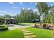 Expansive backyard features a sparkling pool, an outdoor kitchen and a cozy fire pit with seating, framed by green space at 150 Trinity Farm Dr, Canton, GA 30115
