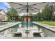 Inviting backyard pool with lounge chairs, umbrella, and outdoor kitchen, perfect for relaxation and entertainment at 150 Trinity Farm Dr, Canton, GA 30115