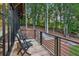 Deck with two chairs and a table overlooking a wooded landscape with a wooden fence at 150 Trinity Farm Dr, Canton, GA 30115