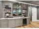 Stylish bar area with wine storage, shelving, cabinets, and a decorative mirror on a brick accent wall at 150 Trinity Farm Dr, Canton, GA 30115