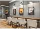 Chic bar area with a wooden counter and four chairs, illuminated by modern sconces at 150 Trinity Farm Dr, Canton, GA 30115