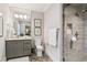Bathroom with a glass enclosed shower, gray vanity, and a decorative mirror at 150 Trinity Farm Dr, Canton, GA 30115