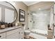 Modern bathroom featuring a glass-enclosed shower and a sleek vanity with a round mirror at 150 Trinity Farm Dr, Canton, GA 30115