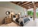 Comfortable bedroom with exposed beams, neutral decor, a king bed, and views of the scenic backyard at 150 Trinity Farm Dr, Canton, GA 30115