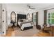 Bright bedroom featuring a large headboard, hardwood floors, and natural light from shuttered windows at 150 Trinity Farm Dr, Canton, GA 30115