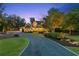 Long driveway leads to an elegant two-story home, complemented by mature trees and landscape lighting at 150 Trinity Farm Dr, Canton, GA 30115
