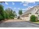 Long paved driveway with a three car garage, manicured bushes, and a separate shed at 150 Trinity Farm Dr, Canton, GA 30115