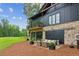 Beautiful exterior with stone, black wood siding, covered patio with seating and a small balcony at 150 Trinity Farm Dr, Canton, GA 30115