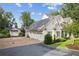Beautiful white farmhouse-style home with three-car garage and lush landscaping, offering timeless elegance at 150 Trinity Farm Dr, Canton, GA 30115