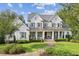 Beautiful two-story farmhouse-style home with covered front porch, detailed trim and landscaping at 150 Trinity Farm Dr, Canton, GA 30115