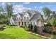 Elegant farmhouse-style home with a sprawling lawn, and mature trees creating a private, park-like setting at 150 Trinity Farm Dr, Canton, GA 30115