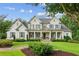 Inviting two-story farmhouse-style home with a welcoming front porch and manicured landscaping at 150 Trinity Farm Dr, Canton, GA 30115