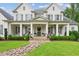 Charming two-story home boasts a manicured lawn, inviting front porch, and classic architectural details at 150 Trinity Farm Dr, Canton, GA 30115