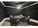 Dark and moody game room with a round table, four chairs and unique ceiling fan at 150 Trinity Farm Dr, Canton, GA 30115
