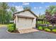 Detached garage featuring a carriage door, metal awning, and access to a pergola-covered outdoor space at 150 Trinity Farm Dr, Canton, GA 30115