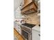 Modern kitchen featuring a stainless steel stove and a wooden hood, with brick backsplash and countertops at 150 Trinity Farm Dr, Canton, GA 30115