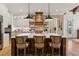 Spacious kitchen with brick accent wall, wooden hood, and large island with counter seating at 150 Trinity Farm Dr, Canton, GA 30115