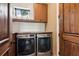 Efficient laundry room with modern washer and dryer, wooden cabinets, and countertop for folding at 150 Trinity Farm Dr, Canton, GA 30115