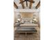 Beautiful main bedroom with brick accent wall, wooden beams, and neutral furniture at 150 Trinity Farm Dr, Canton, GA 30115