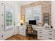 Bright home office featuring brick accent wall and modern desk setup at 150 Trinity Farm Dr, Canton, GA 30115