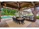 Outdoor kitchen with built-in grill, pizza oven, dining table, and a view of the pool at 150 Trinity Farm Dr, Canton, GA 30115