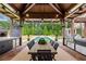 Open-air kitchen with stainless steel appliances, pizza oven, and dining area overlooking the pool at 150 Trinity Farm Dr, Canton, GA 30115