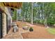 Inviting stone patio features ample seating and leads to a beautifully landscaped backyard with mature trees at 150 Trinity Farm Dr, Canton, GA 30115