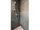Modern shower featuring gray tile and river rock flooring, creating a sleek and spa-like experience at 150 Trinity Farm Dr, Canton, GA 30115
