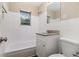 White bathroom featuring a shower-tub combo, granite vanity, and a window with natural light at 1829 Goddard Se St, Atlanta, GA 30315