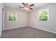 Bedroom with neutral walls and carpet, flooded with natural light from two windows and fan overhead at 1829 Goddard Se St, Atlanta, GA 30315