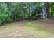 An empty backyard ready to be styled for the ultimate outdoor living experience, with a treeline in the background at 2247 Cherokee Valley Dr, Lithonia, GA 30058