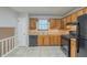 Kitchen features tile flooring, oak cabinets, and black appliances at 2247 Cherokee Valley Dr, Lithonia, GA 30058
