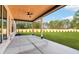 Covered back porch featuring a stained wood ceiling, concrete patio, and a spacious backyard at 3735 Tamiami Trl, Cumming, GA 30041