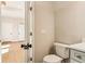 Well-lit bathroom with toilet, vanity, white quartz countertop, and black hardware near partially opened door at 3735 Tamiami Trl, Cumming, GA 30041