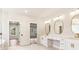 A bright primary bathroom with double vanity and open doorway that leads into an adjoining room at 3735 Tamiami Trl, Cumming, GA 30041