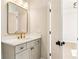 Well-lit bathroom featuring white quartz countertop, gold fixtures, vanity and a framed mirror at 3735 Tamiami Trl, Cumming, GA 30041
