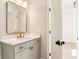 Chic bathroom vanity featuring gold fixtures and hardware and a stylish mirror at 3735 Tamiami Trl, Cumming, GA 30041
