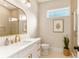 Well-lit bathroom featuring a vanity with gold fixtures, decorative mirror, and shower stall with glass door at 3735 Tamiami Trl, Cumming, GA 30041