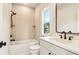 Bright bathroom featuring a tub with shower, and a sink with stylish fixtures and hardware at 3735 Tamiami Trl, Cumming, GA 30041