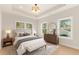 Bright and airy bedroom with three windows, light hardwood floors, and dresser with round mirror at 3735 Tamiami Trl, Cumming, GA 30041