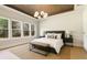 A serene bedroom with a tray ceiling, plenty of natural light, and neutral decor at 3735 Tamiami Trl, Cumming, GA 30041