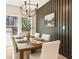 Beautiful dining room with modern chandelier, wood accent wall, and lots of natural light at 3735 Tamiami Trl, Cumming, GA 30041