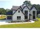 Stunning two-story home with a painted brick facade, modern windows, a clean lawn and lush landscaping at 3735 Tamiami Trl, Cumming, GA 30041